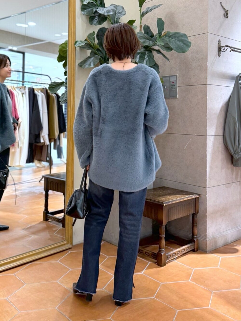 ブルー系のカーディガン/ボレロ、ブルー系のデニムパンツ、ブラック系のショルダーバッグを着用したレディースの秋コーディネートの3枚目の写真