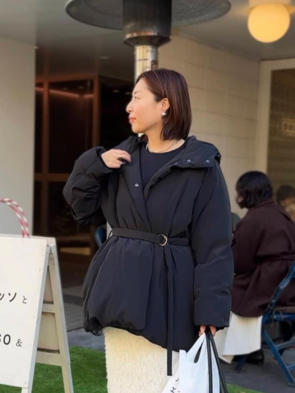 ブラック系のダウンジャケット/コート、ホワイト系のスカートを着用したレディースの冬コーディネートの3枚目の写真