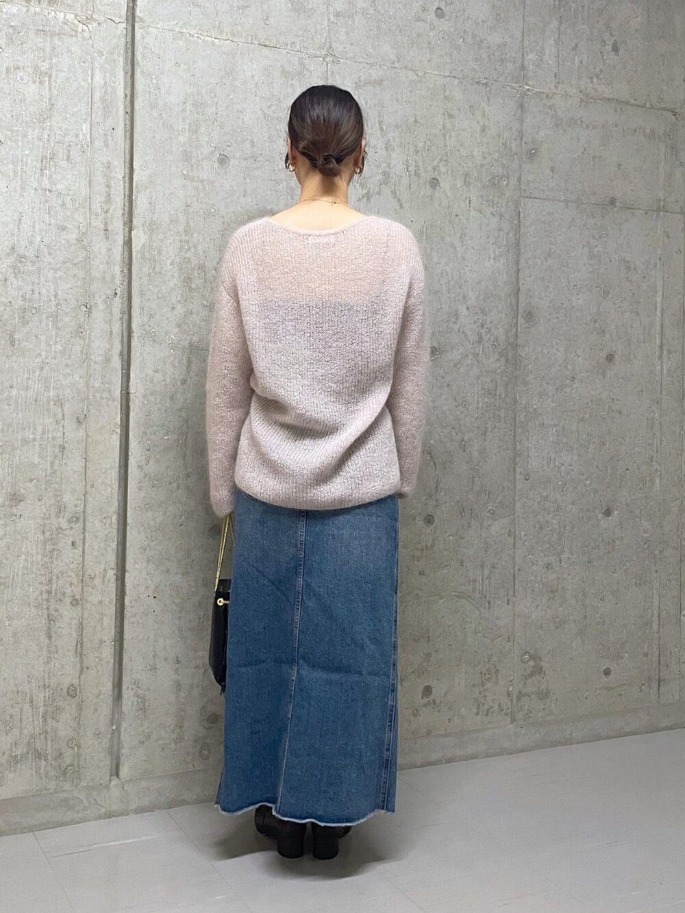 ピンク系のニット/セーター、ブルー系のデニムスカート、ブラウン系のブーツを着用したレディースの秋コーディネートの3枚目の写真