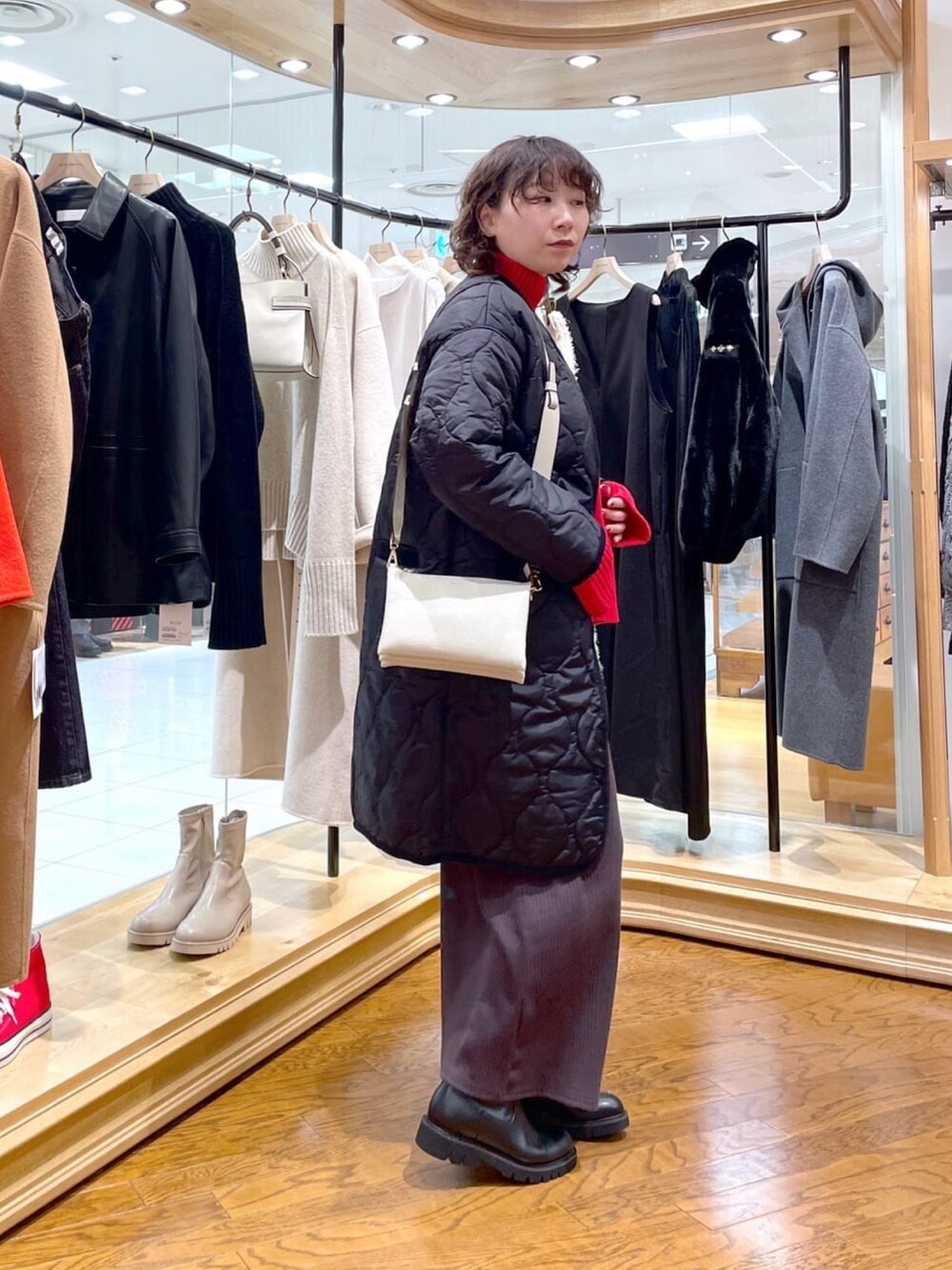 ブラック系のダウンジャケット/コート、ブラウン系のワンピースを着用したレディースの冬コーディネートの3枚目の写真