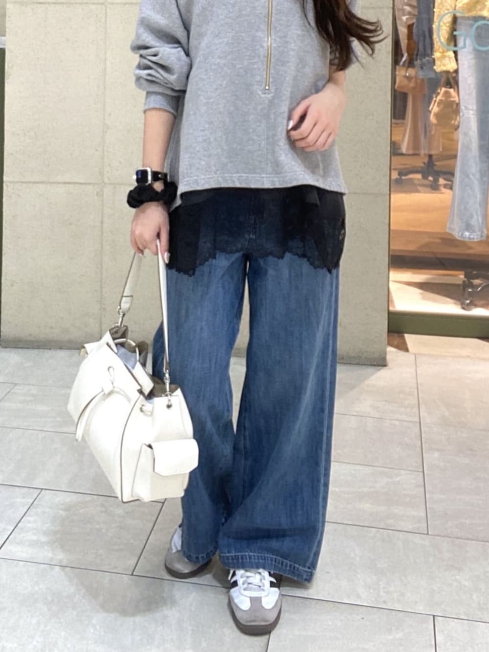 グレー系のスウェット、ブラウン系のキャミソール、ホワイト系のショルダーバッグを着用したレディースの春コーディネートの7枚目の写真