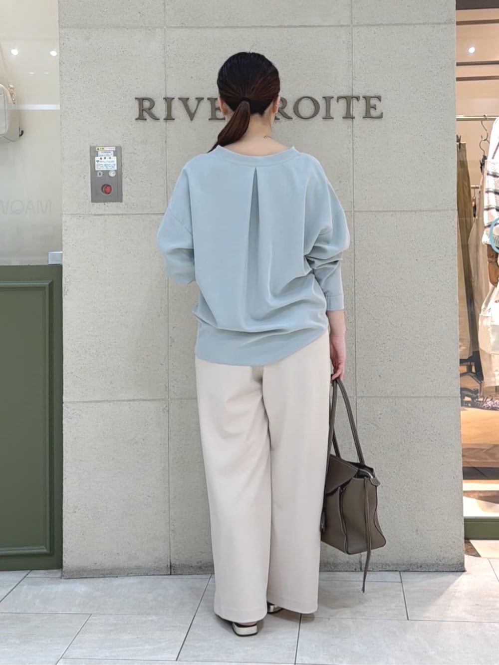 ブラウン系のその他シューズ、ブラウン系のトートバッグ、グリーン系のシャツ/ブラウスを着用したレディースの春コーディネートの4枚目の写真