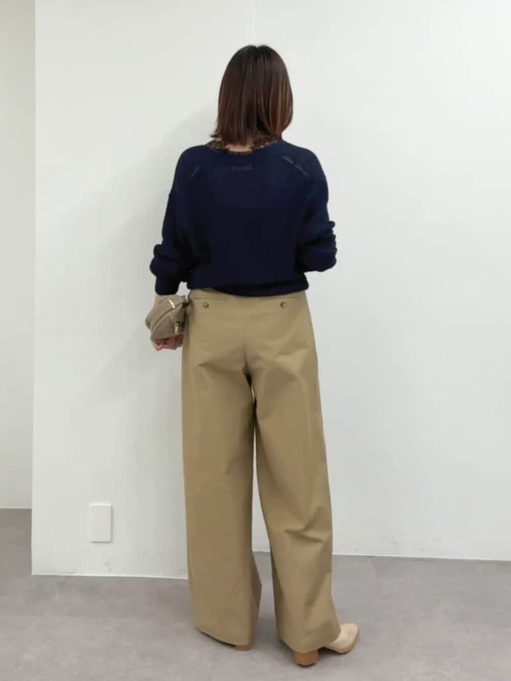 ベージュ系のその他シューズ、ベージュ系のショルダーバッグ、ブルー系のニット/セーターを着用したレディースの春コーディネートの2枚目の写真