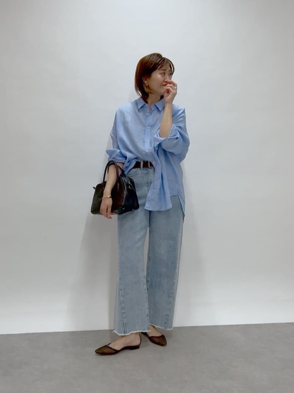 ブルー系のデニムパンツ、ブルー系のシャツ/ブラウス、ブラック系のパンプスを着用したレディースの冬コーディネートの2枚目の写真