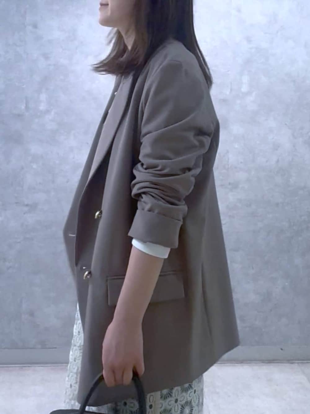 ホワイト系のスウェット、ブラウン系のテーラードジャケット、ブラック系のボストンバッグを着用したレディースの冬コーディネートの7枚目の写真