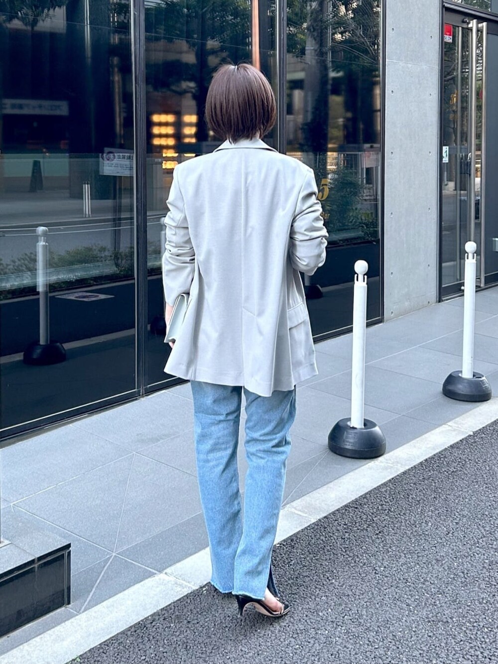 ブルー系のニット/セーター、グレー系のテーラードジャケット、ブルー系のショルダーバッグを着用したレディースの春コーディネートの3枚目の写真