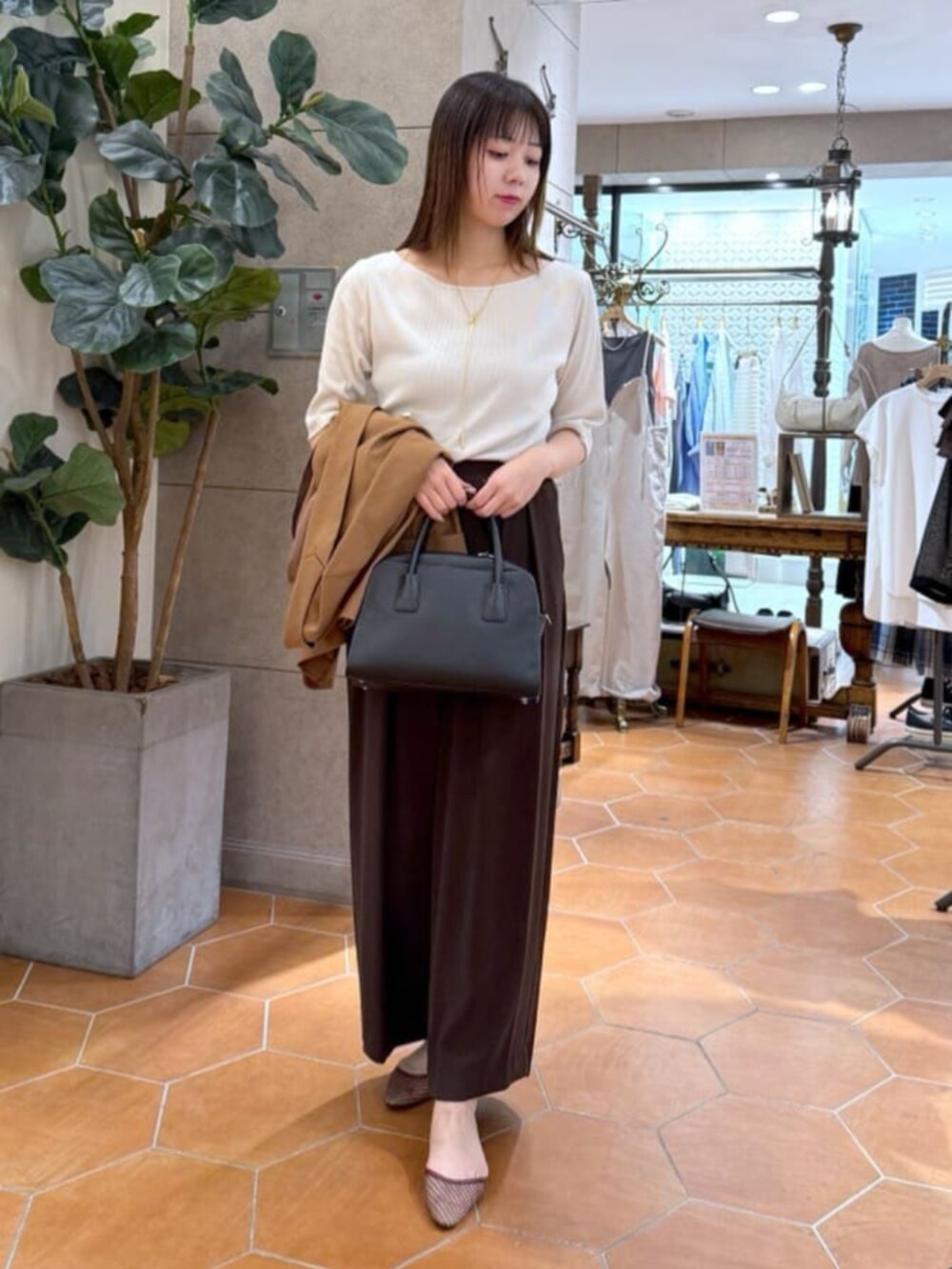 ベージュ系のTシャツ/カットソー、ブラック系のボストンバッグ、ブラウン系のテーラードジャケットを着用したレディースの夏コーディネートの2枚目の写真