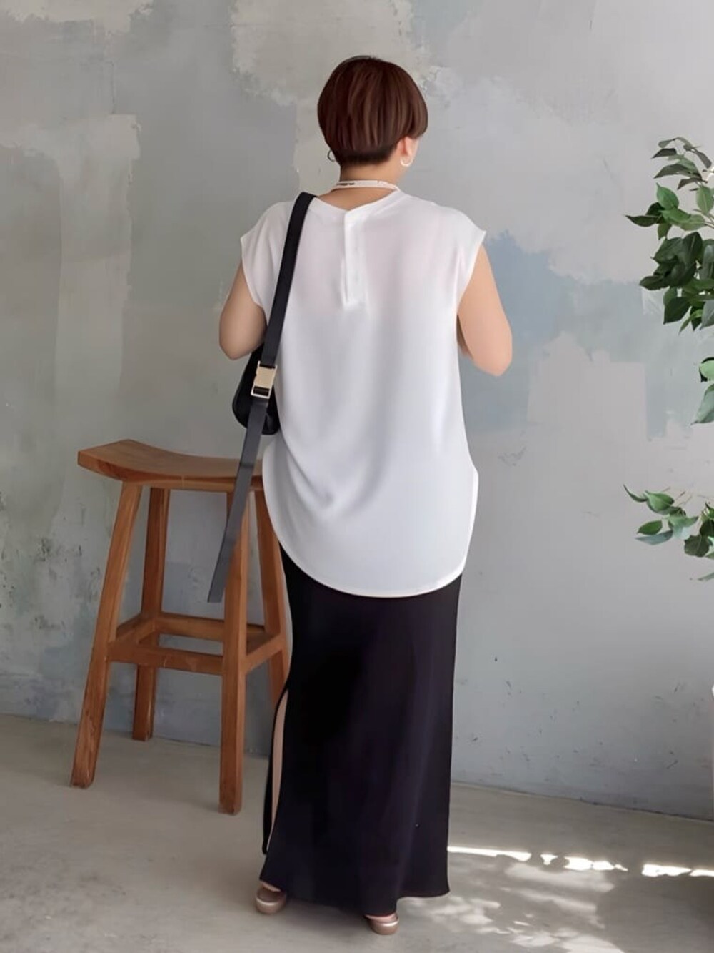 ホワイト系のシャツ/ブラウス、ブラック系のスカート、シルバー系のサンダルを着用したレディースの夏コーディネートの2枚目の写真