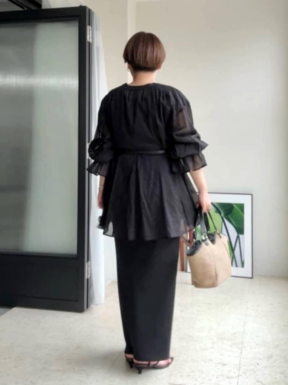 ブラック系のワンピース、ブラック系のサンダル、ブラック系のシャツ/ブラウスを着用したレディースの春コーディネートの2枚目の写真