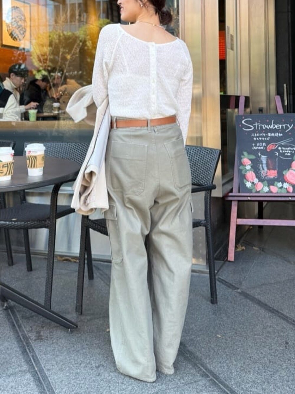 ホワイト系のTシャツ/カットソー、ベージュ系のピーコート、グリーン系のカーゴパンツを着用したレディースの冬コーディネートの3枚目の写真