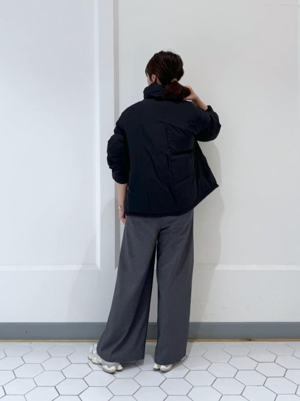 ブラック系のダウンジャケット/コート、グレー系のニット/セーター、グレー系のその他パンツを着用したレディースの冬コーディネートの4枚目の写真