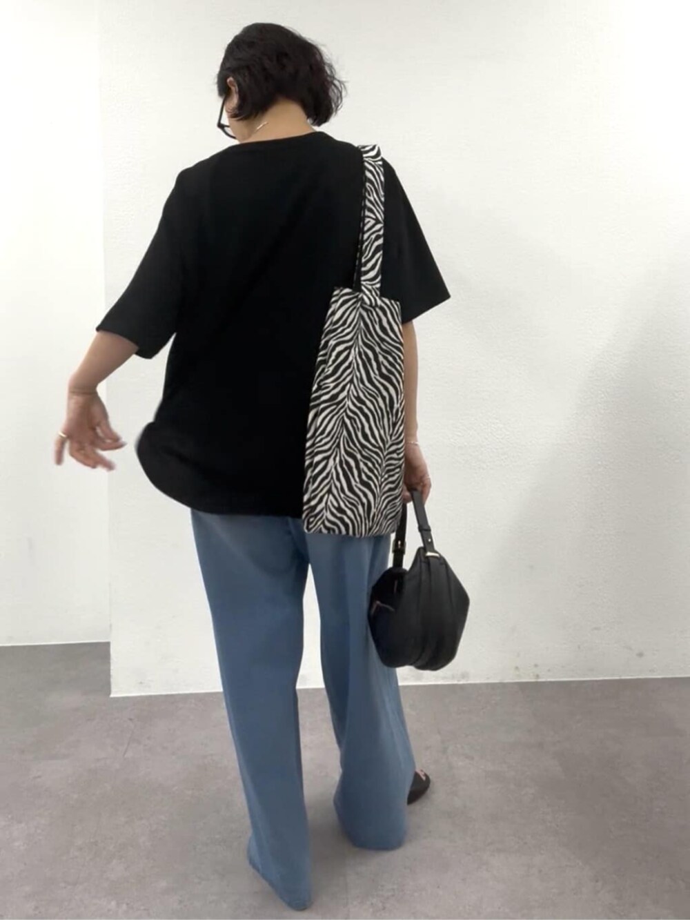 ブラック系のショルダーバッグ、ブラック系のTシャツ/カットソー、ブラック系のトートバッグを着用したレディースの春コーディネートの7枚目の写真