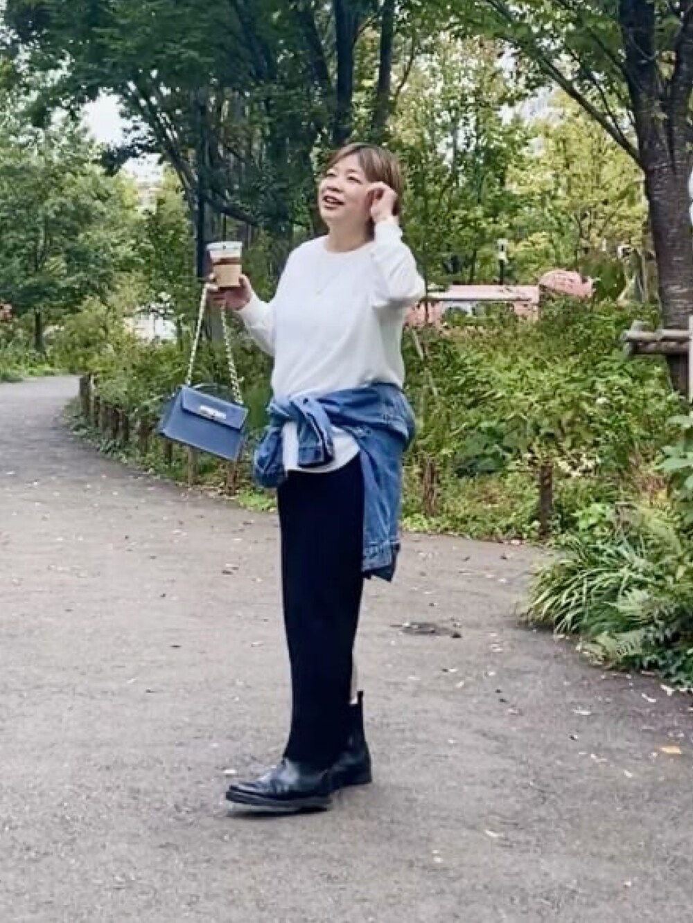 グレー系のシャツ/ブラウス、ブルー系のハンドバッグ、ブラック系のスカートを着用したレディースの春コーディネートの3枚目の写真