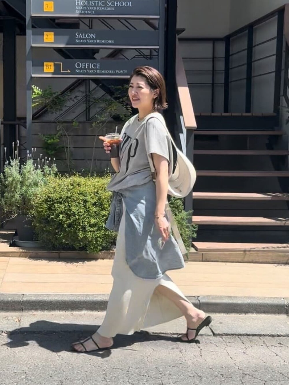 ホワイト系のスカート、ブラック系のサンダル、ブルー系のシャツ/ブラウスを着用したレディースの春コーディネートの2枚目の写真