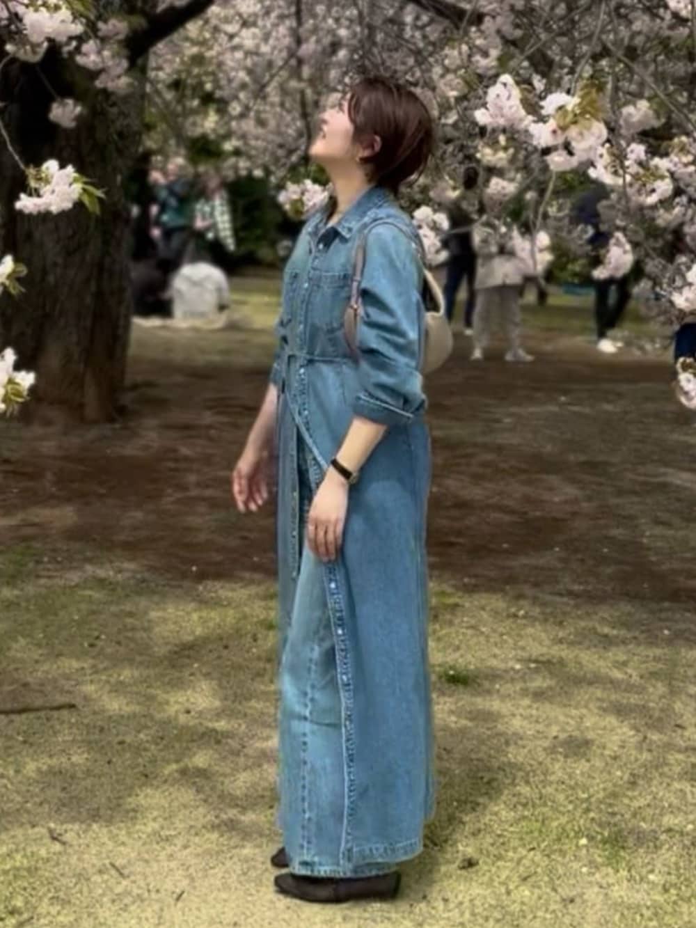 ブラック系のその他シューズ、ブルー系のデニムパンツ、ブルー系のワンピースを着用したレディースの春コーディネートの5枚目の写真