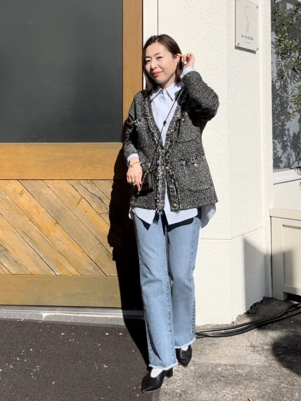 ブラウン系のカーディガン/ボレロ、ブルー系のデニムパンツ、グリーン系のショルダーバッグを着用したレディースの冬コーディネートの3枚目の写真