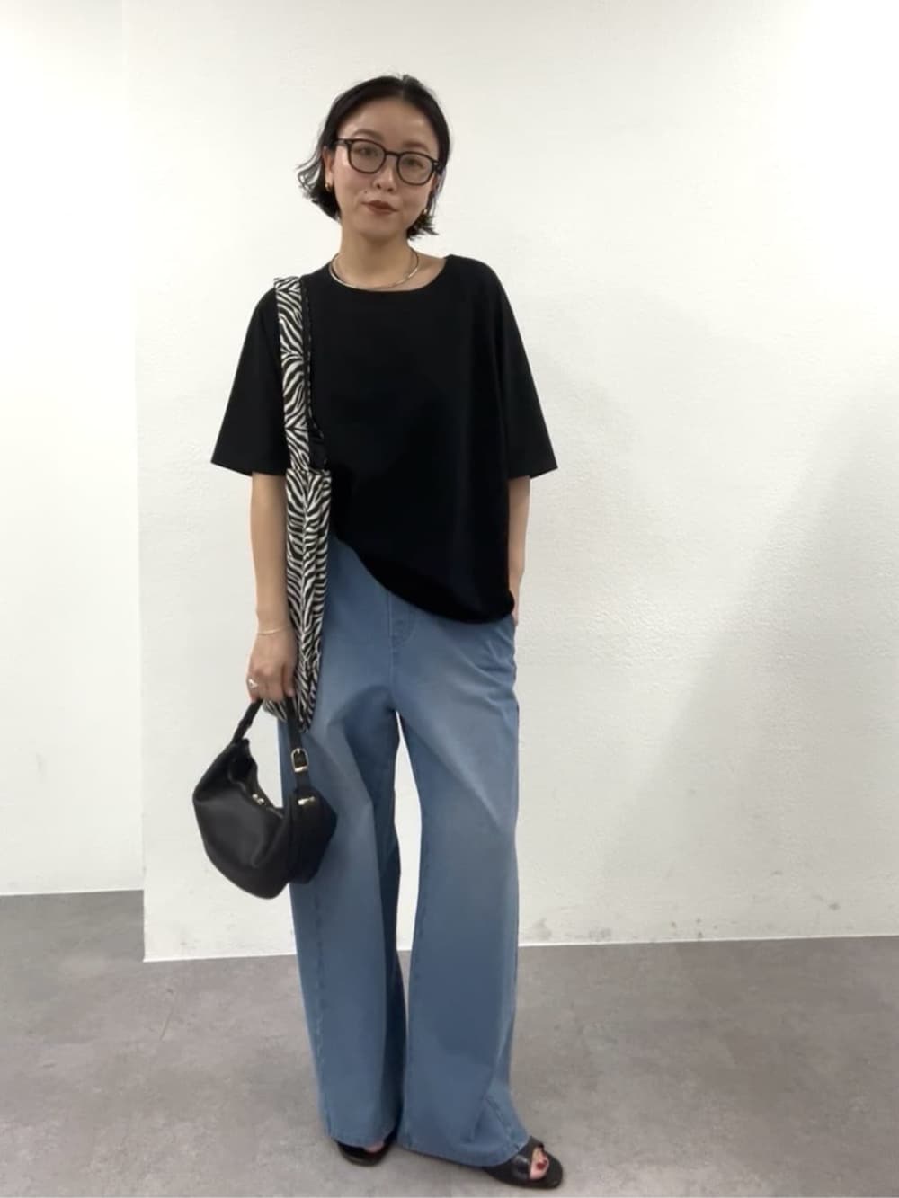 ブラック系のショルダーバッグ、ブラック系のTシャツ/カットソー、ブラック系のトートバッグを着用したレディースの春コーディネートの5枚目の写真