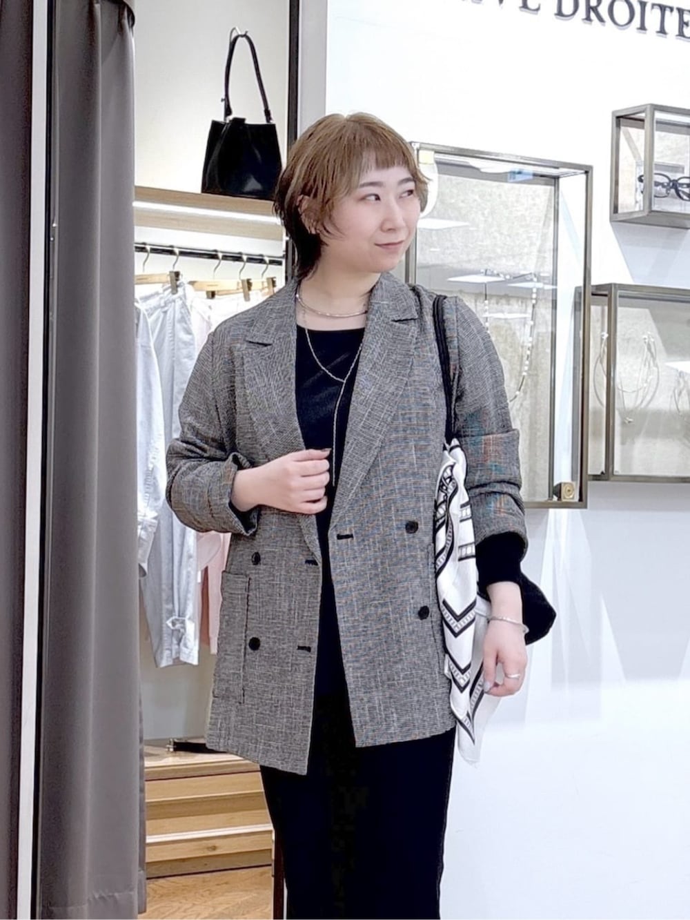 ブラック系のその他パンツ、ブラック系のテーラードジャケット、ブラック系のトートバッグを着用したレディースの春コーディネートの4枚目の写真