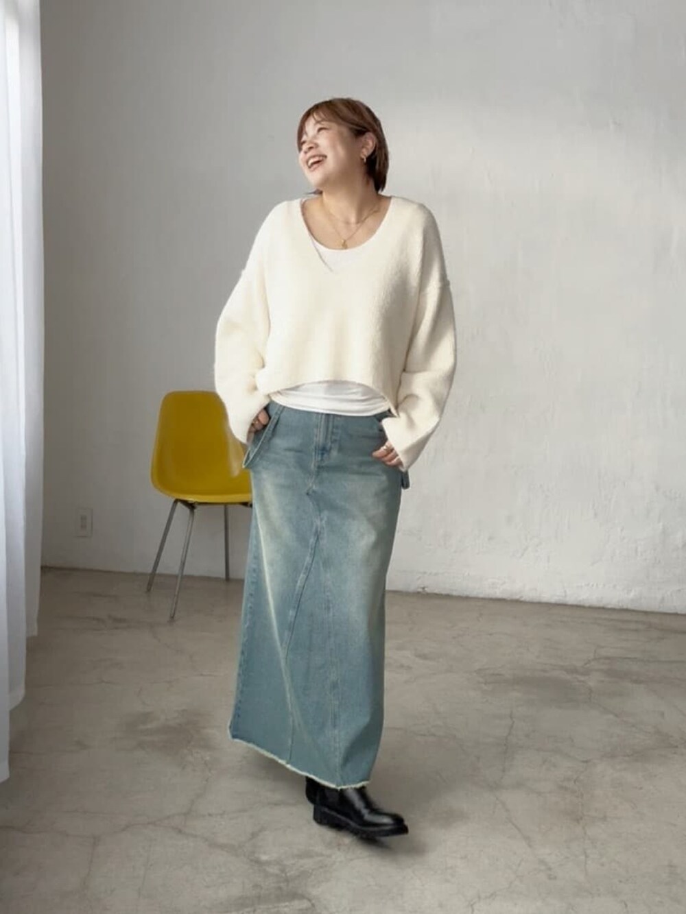 ホワイト系のニット/セーター、ブルー系のデニムスカートを着用したレディースの秋コーディネートの3枚目の写真