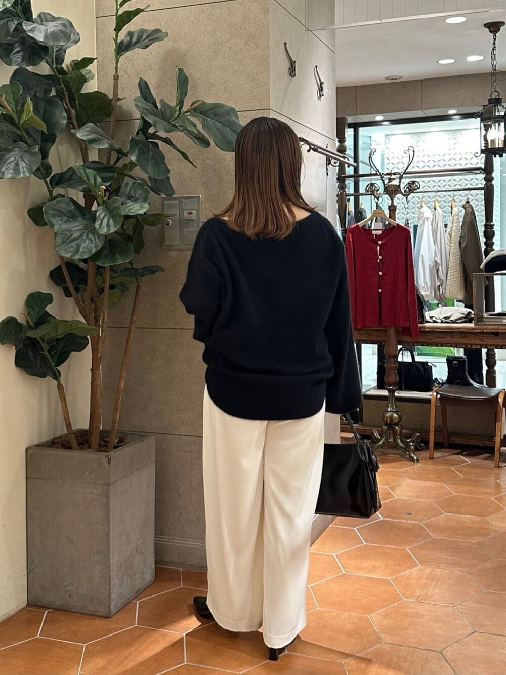 ブラック系のニット/セーター、グレー系のスラックス、ブラック系のローファーを着用したレディースの冬コーディネートの3枚目の写真