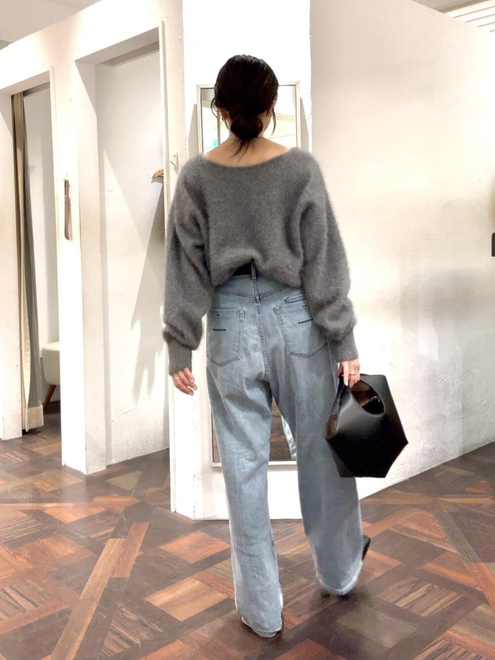 グレー系のニット/セーター、ブラック系のハンドバッグ、ブラック系のベルトを着用したレディースの冬コーディネートの2枚目の写真