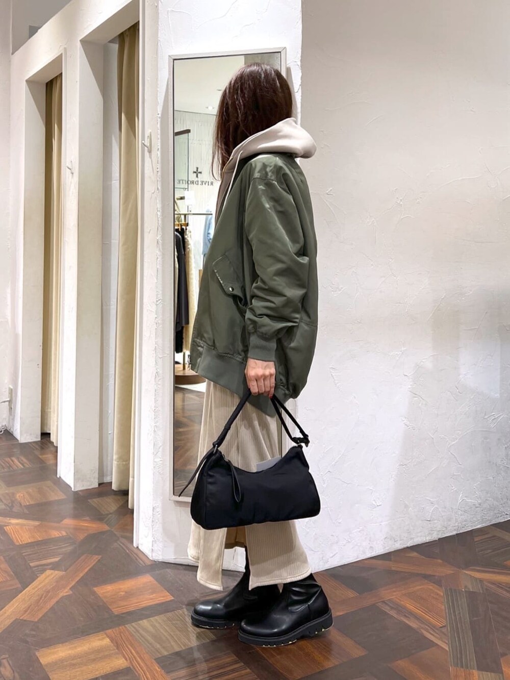 グリーン系のMA-1、ベージュ系のワンピース、ブラック系のブーツを着用したレディースの秋コーディネートの3枚目の写真