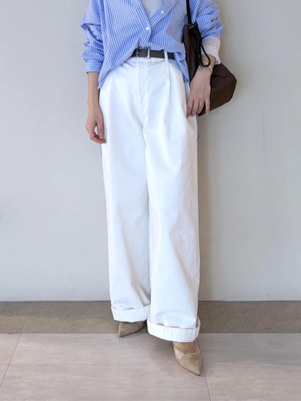 ベージュ系のパンプス、ホワイト系のTシャツ/カットソー、ホワイト系のデニムパンツを着用したレディースの冬コーディネートの7枚目の写真