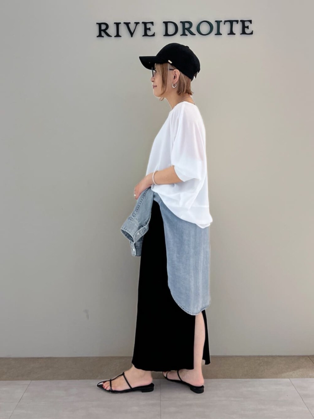 ホワイト系のシャツ/ブラウス、ブルー系のシャツ/ブラウス、ブラック系のスカートを着用したレディースの春コーディネートの2枚目の写真