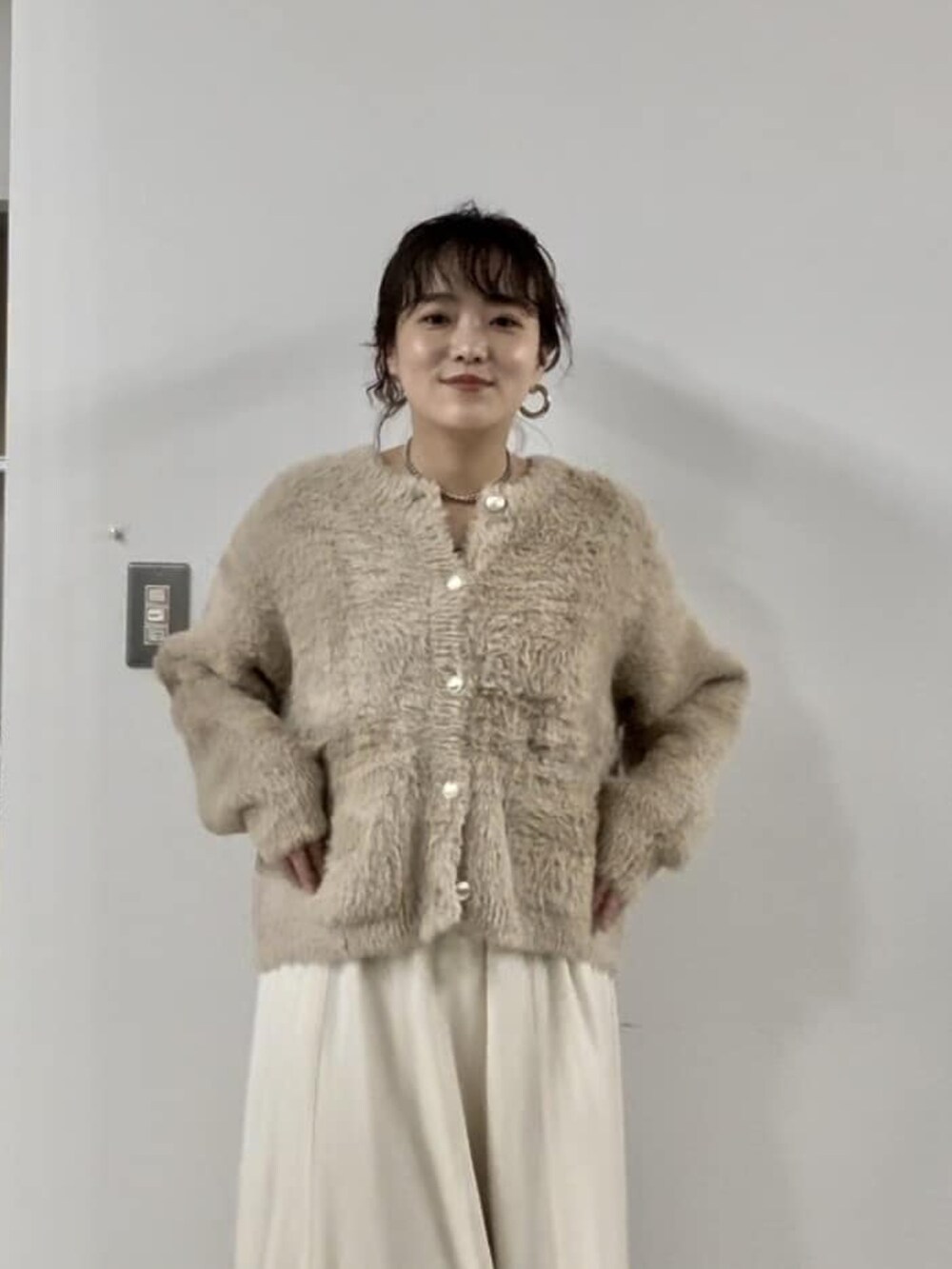 グレー系のカーディガン/ボレロ、ブラウン系のスカート、ブラック系のブーツを着用したレディースの冬コーディネートの3枚目の写真