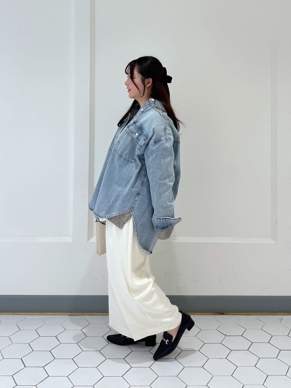 ブルー系のシャツ/ブラウス、ブラウン系のニット/セーター、ホワイト系のスラックスを着用したレディースの冬コーディネートの2枚目の写真