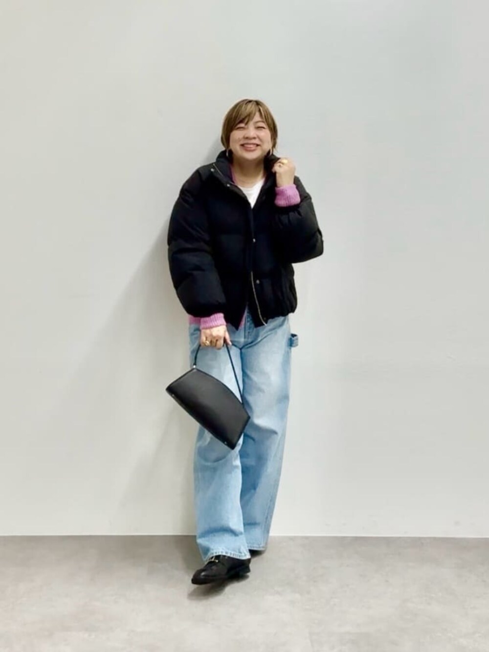 ブラック系のハンドバッグ、ブラック系のダウンジャケット/コート、ピンク系のカーディガン/ボレロを着用したレディースの秋コーディネートの2枚目の写真