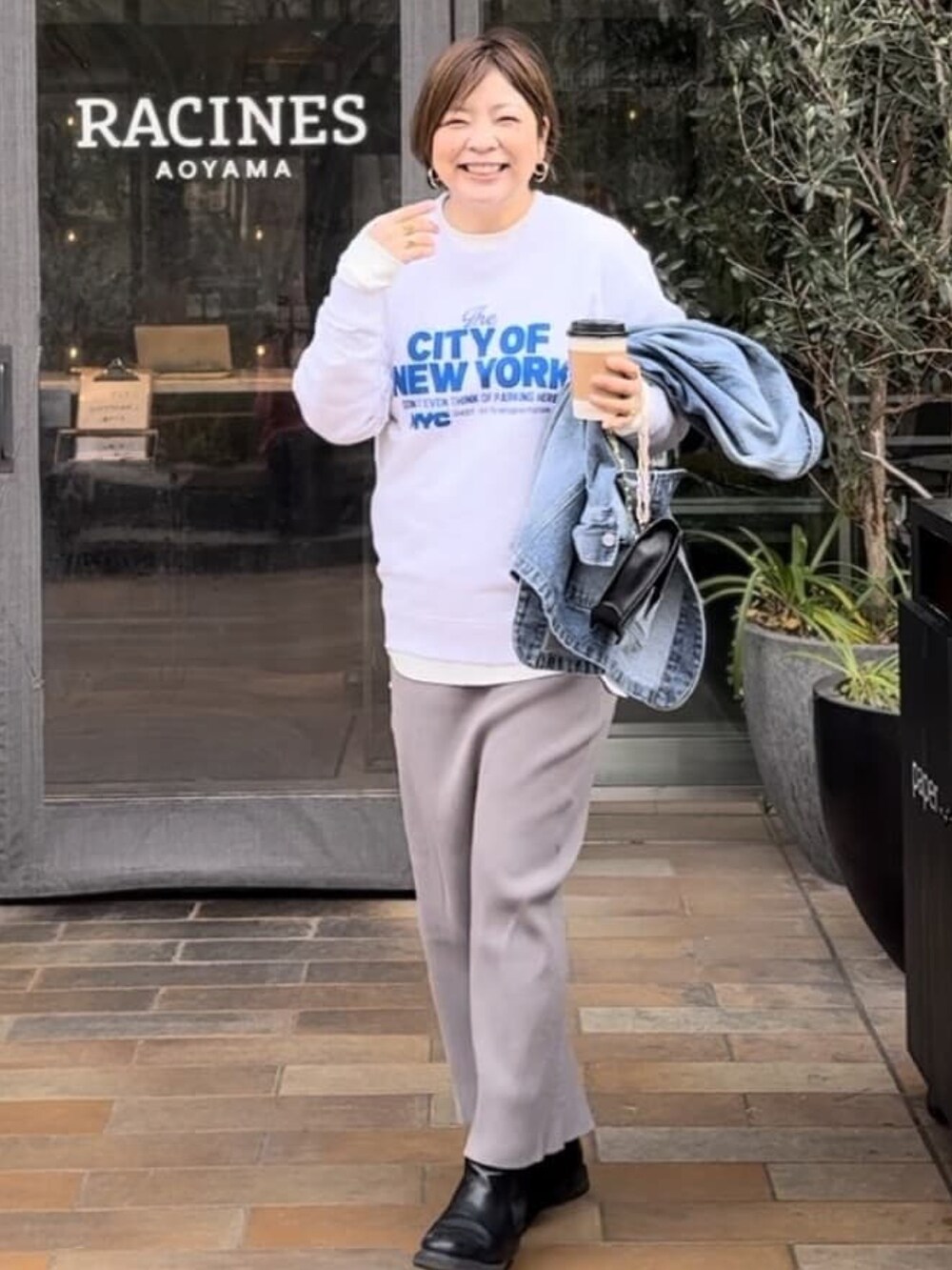 グレー系のスウェット、ブラック系のスカート、ブラック系のブーツを着用したレディースの冬コーディネートの4枚目の写真