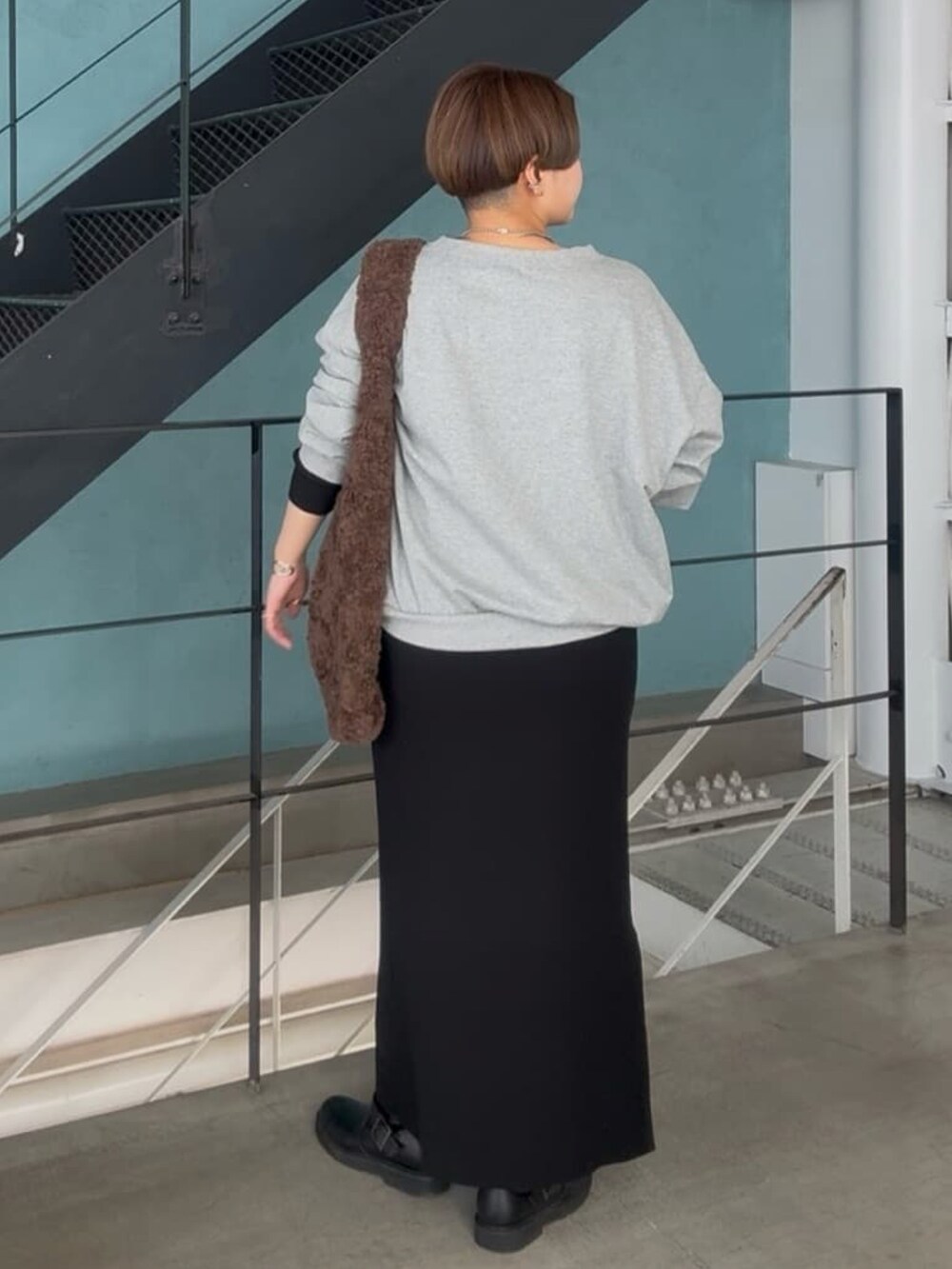 グレー系のスウェット、ブラック系のワンピースを着用したレディースの冬コーディネートの3枚目の写真