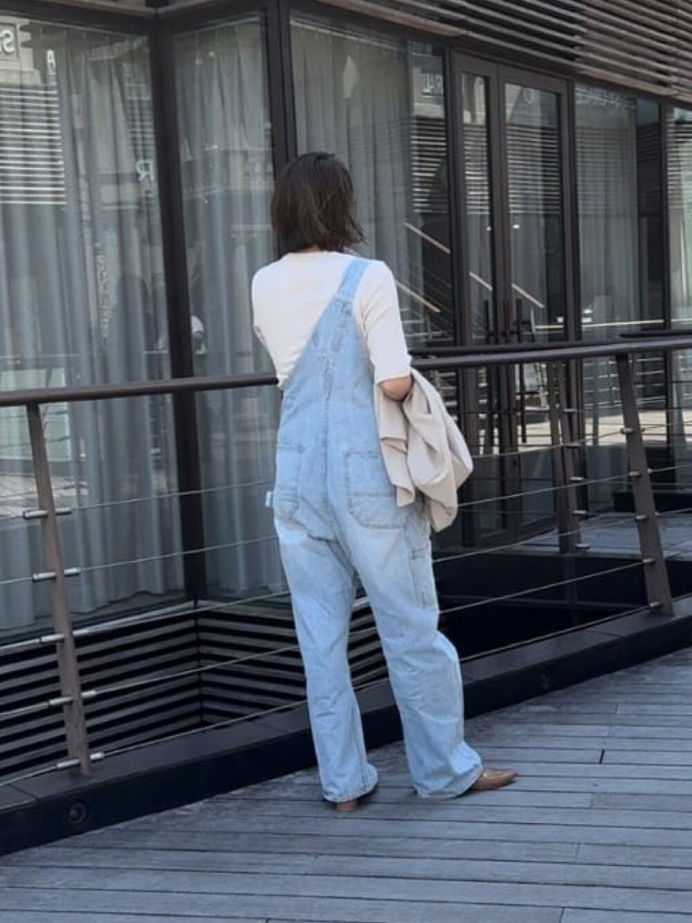 ブルー系のサロペット/オーバーオール、グレー系のTシャツ/カットソーを着用したレディースの春コーディネートの4枚目の写真