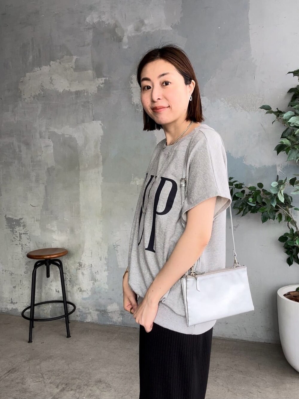 ブラック系のワンピース、ブラック系のサンダル、グレー系のTシャツ/カットソーを着用したレディースの春コーディネートの5枚目の写真