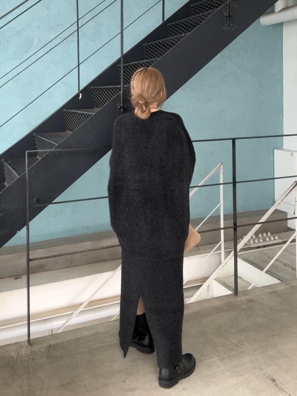 ブラック系のカーディガン/ボレロ、ブラック系のスカート、ベージュ系のハンドバッグを着用したレディースの秋コーディネートの4枚目の写真