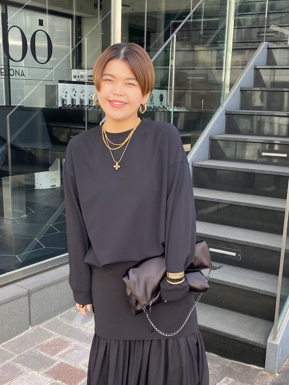 ブラック系のTシャツ/カットソー、ブラック系のスカート、ブラック系のショルダーバッグを着用したレディースの冬コーディネートの2枚目の写真