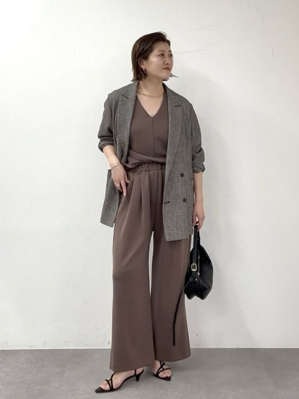 ベージュ系のその他シューズ、ゴールド系のショルダーバッグ、ブラウン系のその他パンツを着用したレディースの春コーディネートの7枚目の写真