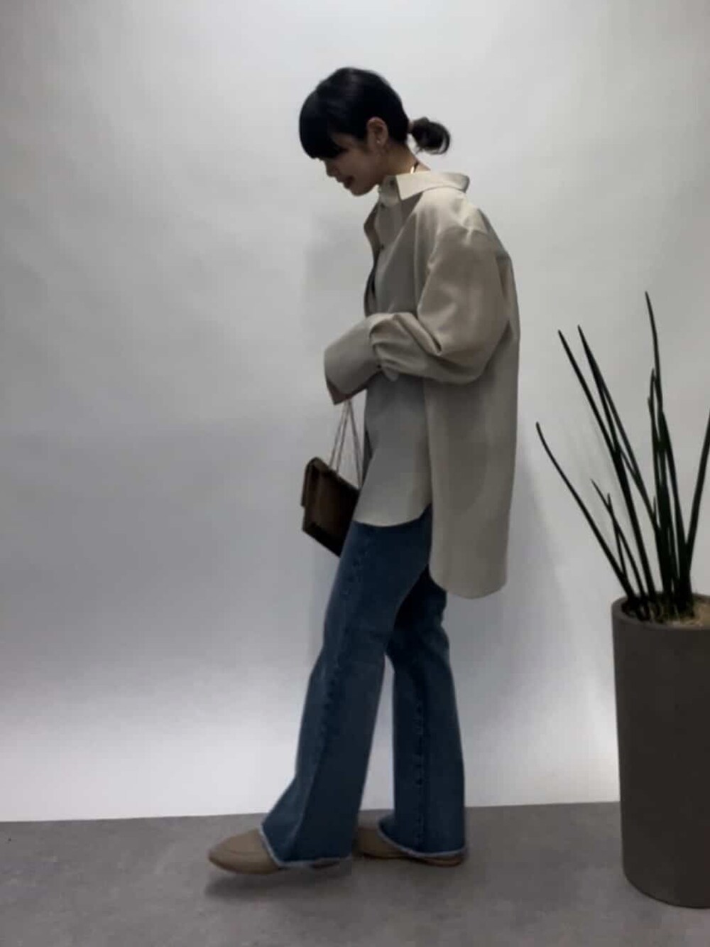 ベージュ系のシャツ/ブラウス、ブルー系のデニムパンツ、ベージュ系のローファーを着用したレディースの春コーディネートの2枚目の写真