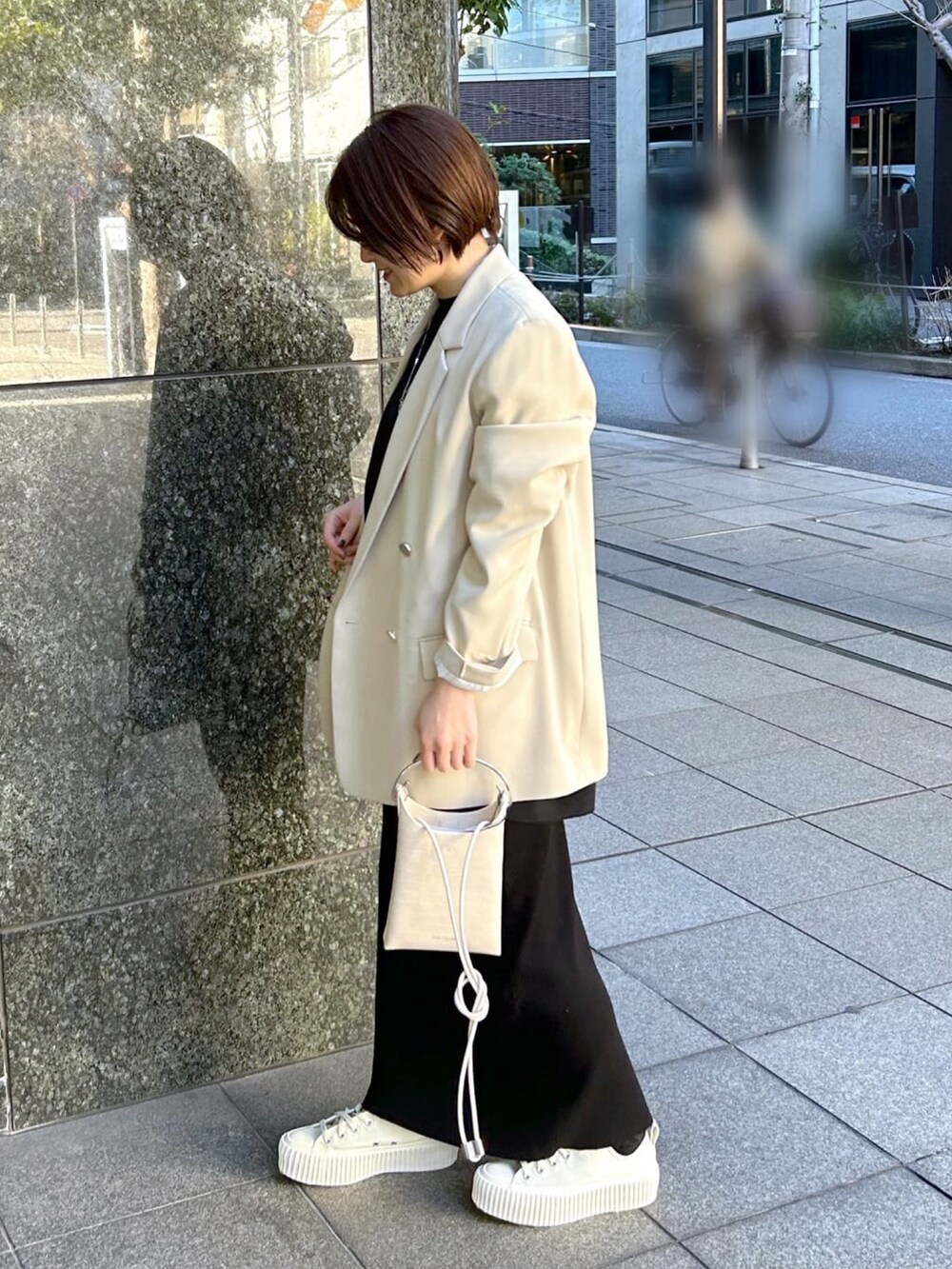 ブラック系のTシャツ/カットソー、ベージュ系のテーラードジャケット、ブラック系のスカートを着用したレディースの春コーディネートの2枚目の写真