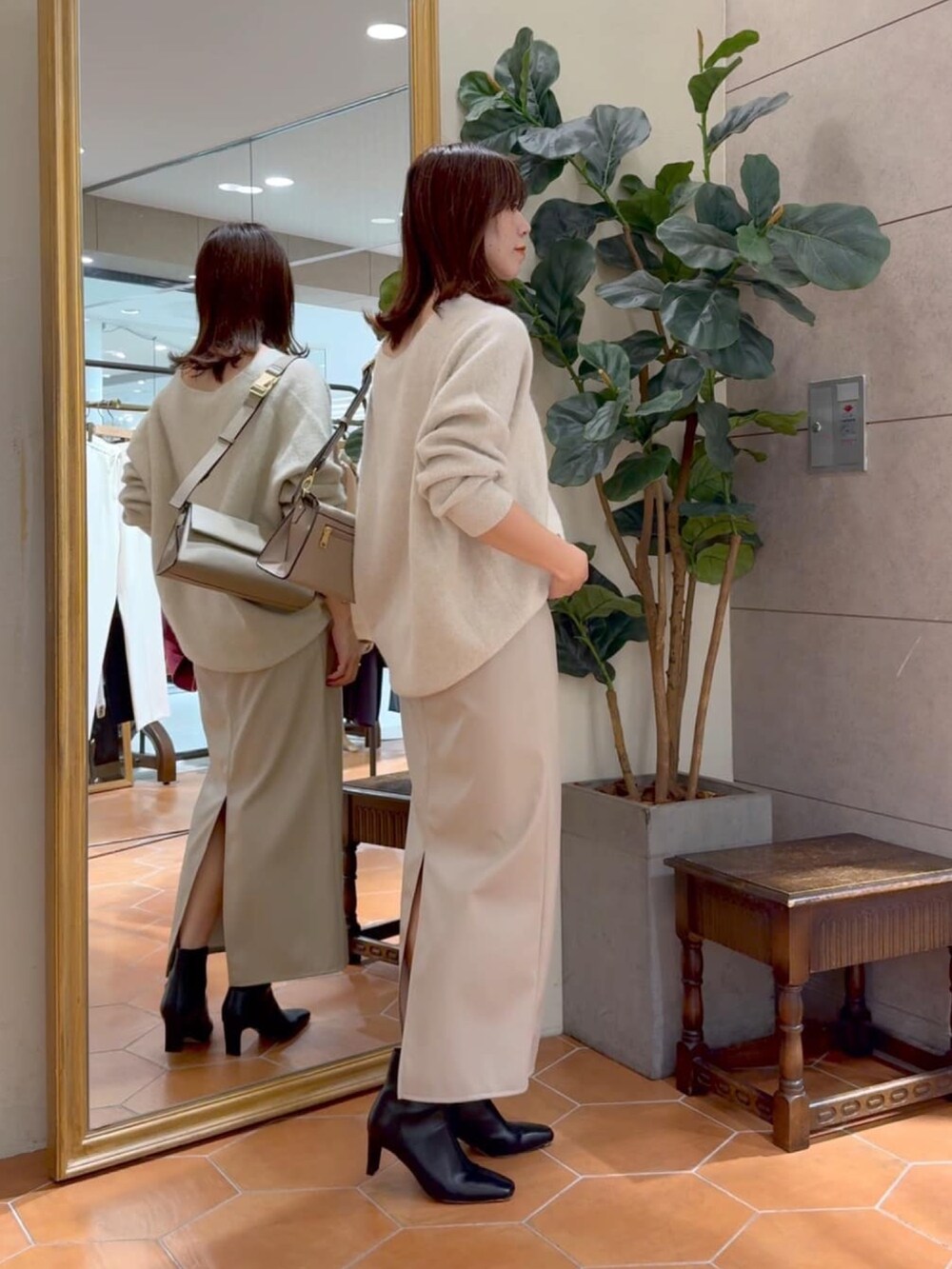 ベージュ系のニット/セーター、ベージュ系のスカート、ブラック系のブーツを着用したレディースの冬コーディネートの2枚目の写真