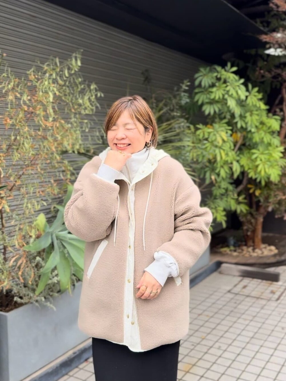 ベージュ系のその他アウター、ブラック系のスカート、ベージュ系のブーツを着用したレディースの冬コーディネートの3枚目の写真