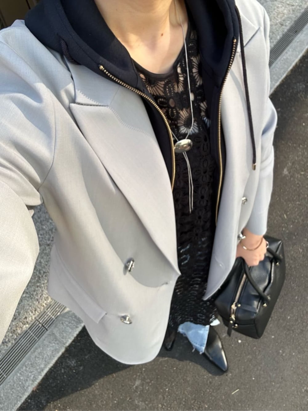 ブルー系のパーカー、ブラック系のボストンバッグ、ブルー系のデニムパンツを着用したレディースの冬コーディネートの3枚目の写真