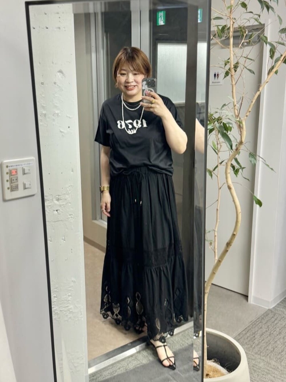 ブラック系のスカート、グレー系のTシャツ/カットソーを着用したレディースの春コーディネートの2枚目の写真