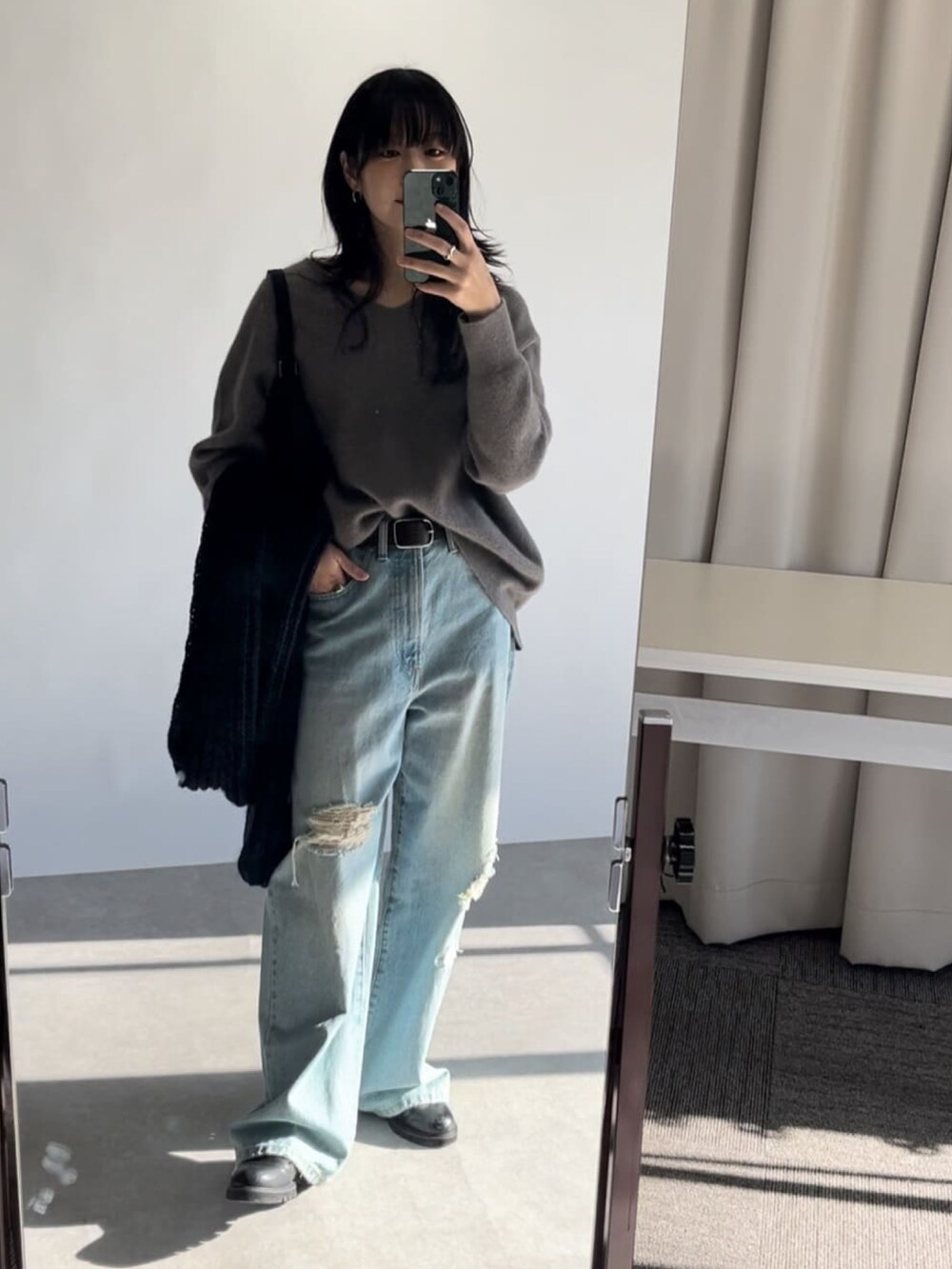 ベージュ系のニット/セーター、ブルー系のデニムパンツ、ブラウン系のステンカラーコートを着用したレディースの冬コーディネートの4枚目の写真