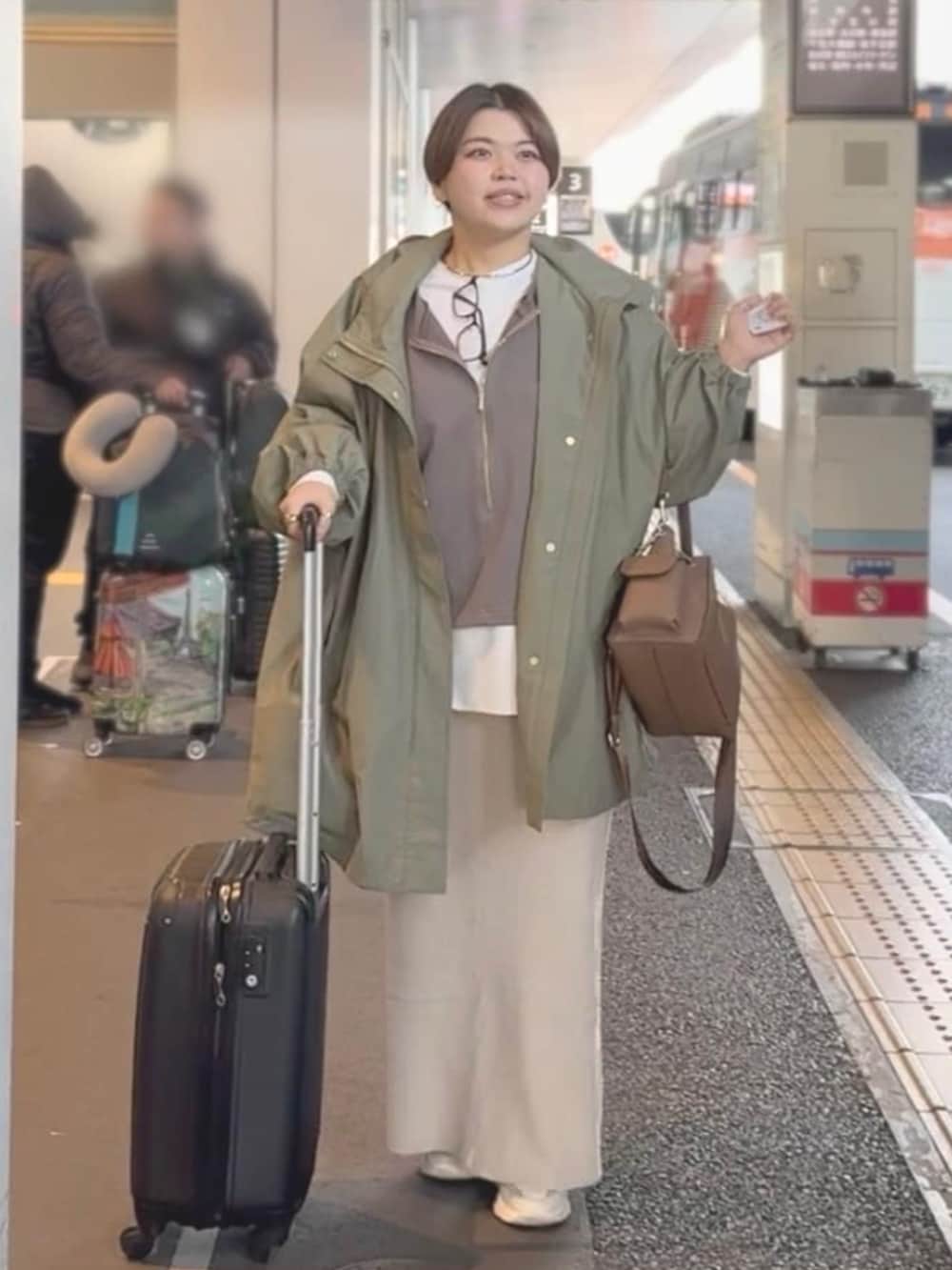 ホワイト系のTシャツ/カットソー、ホワイト系のスカート、グリーン系のその他アウターを着用したレディースの冬コーディネートの2枚目の写真