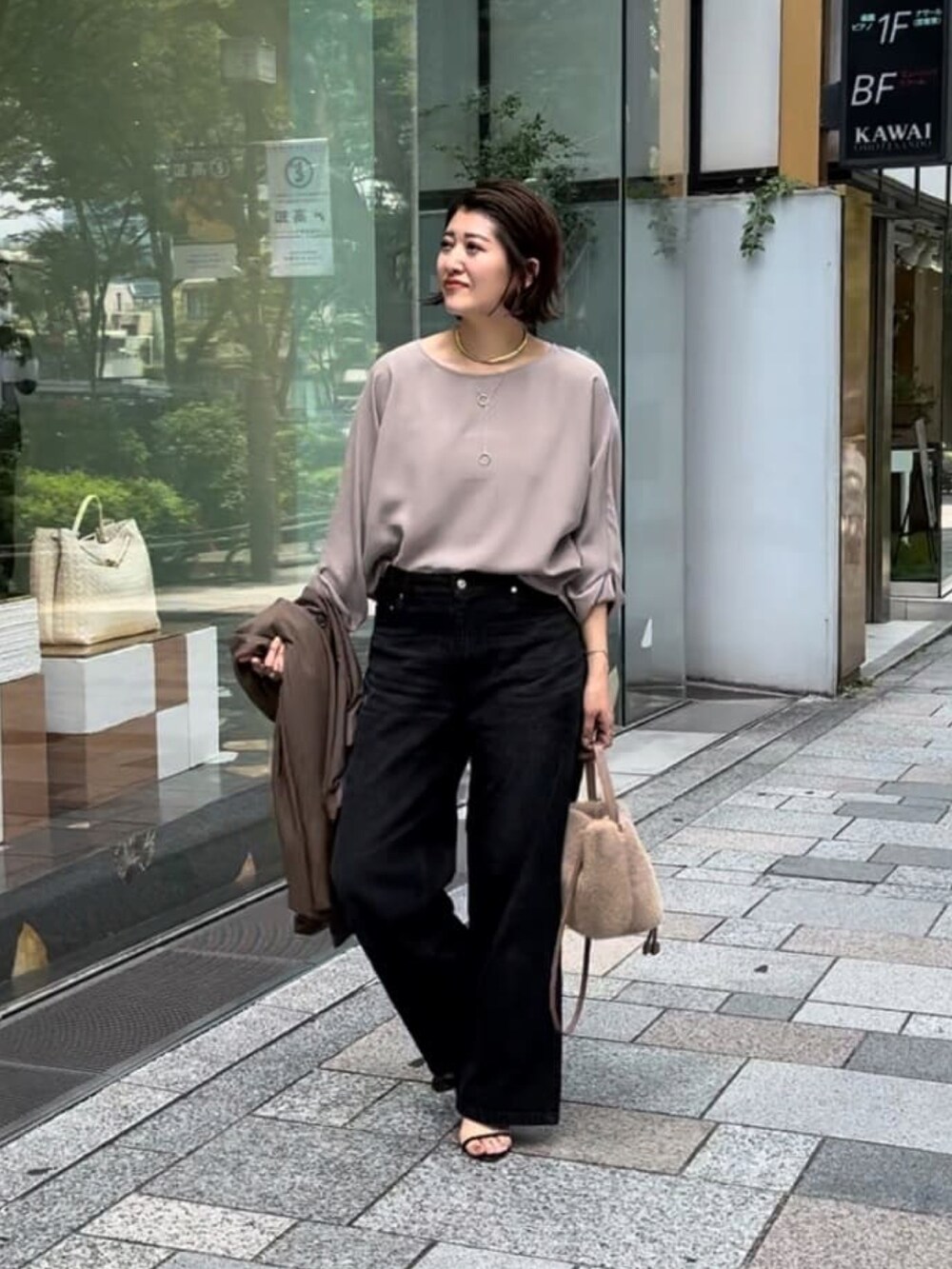 グレー系のシャツ/ブラウス、ブラック系のデニムパンツ、ベージュ系のハンドバッグを着用したレディースの夏コーディネートの2枚目の写真