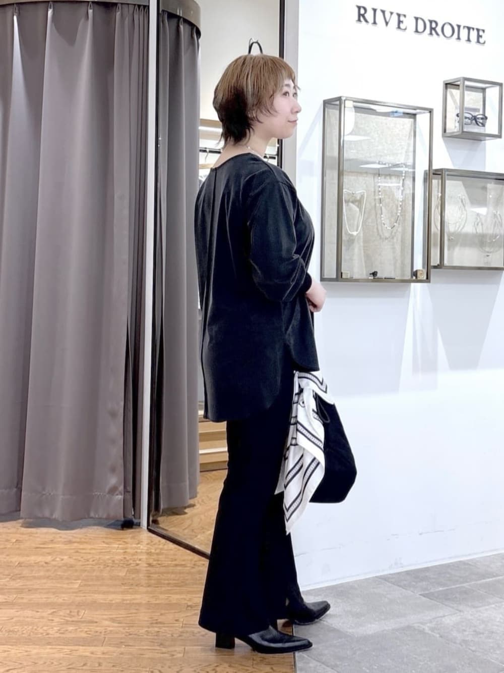 ブラック系のその他パンツ、ブラック系のテーラードジャケット、ブラック系のトートバッグを着用したレディースの春コーディネートの10枚目の写真