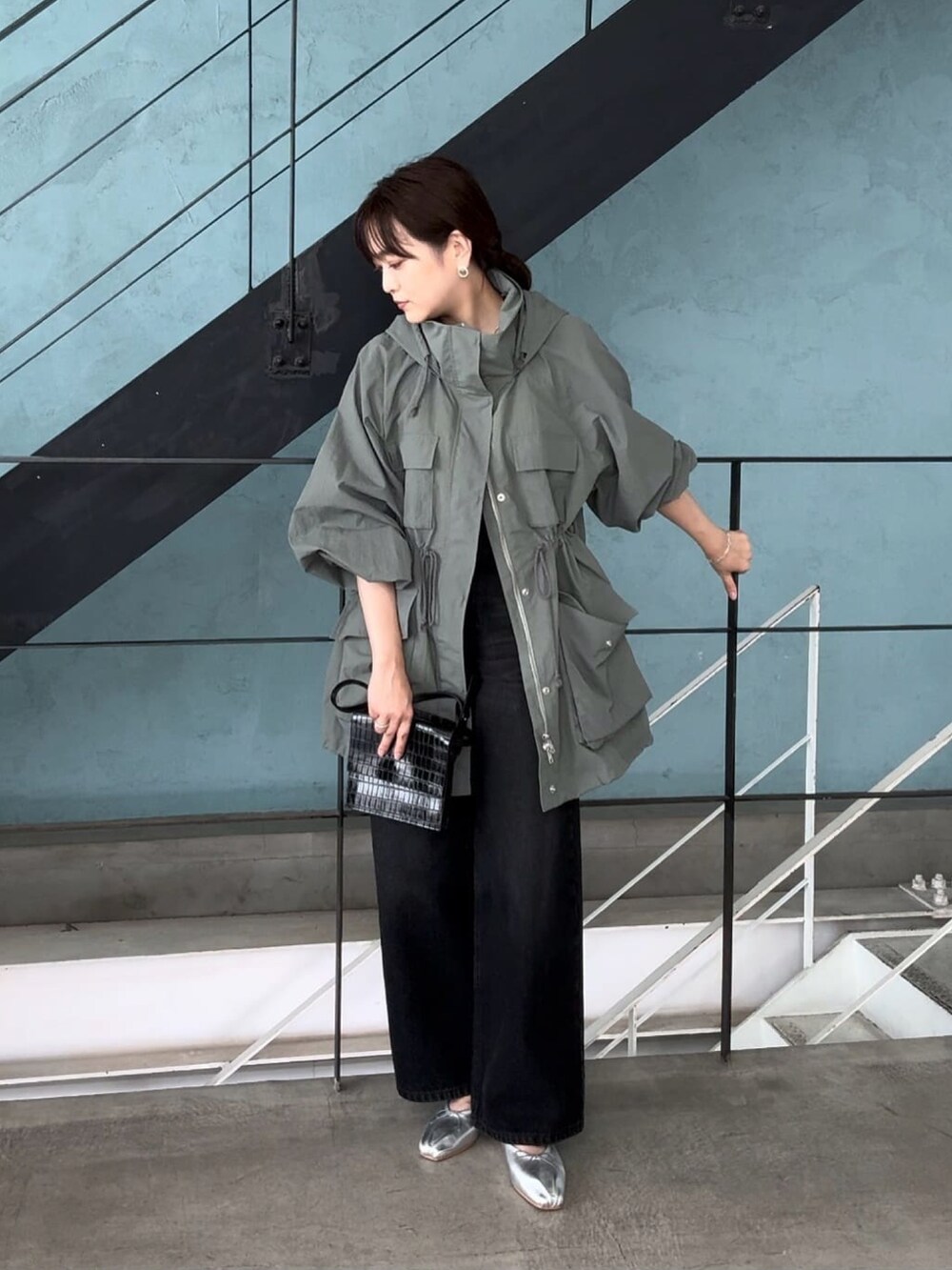 グリーン系のマウンテンパーカー、ブラック系のデニムパンツを着用したレディースの夏コーディネートの2枚目の写真