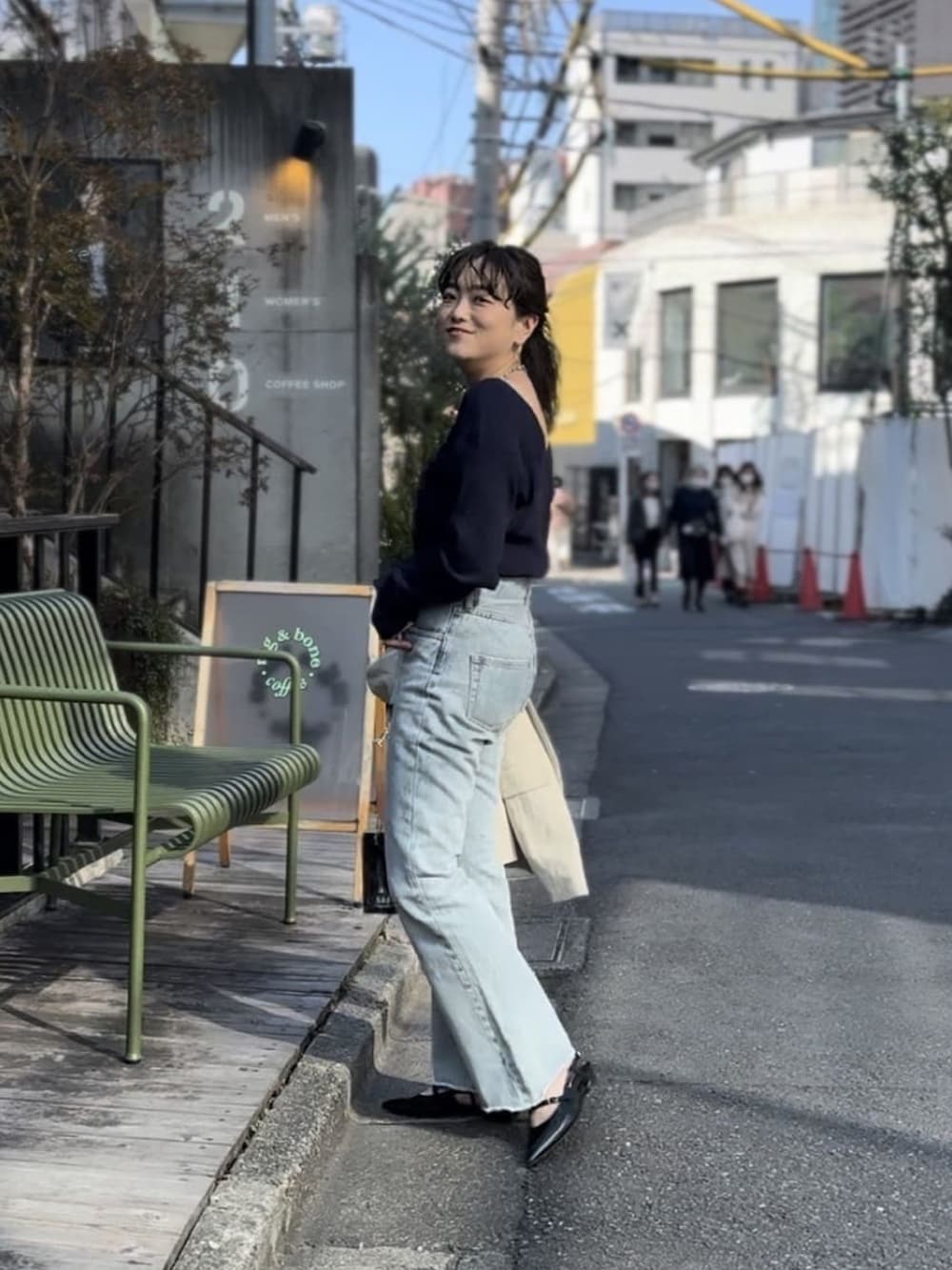 ブルー系のニット/セーター、ブルー系のデニムパンツ、ブラック系のパンプスを着用したレディースの冬コーディネートの2枚目の写真